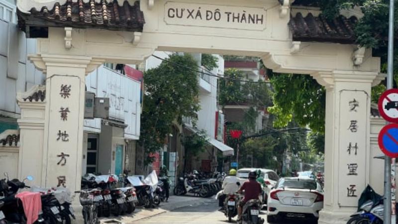 Hình ảnh thể hiện sự tương phản giữa Chung cư Tôn Thất Đạm cũ kỹ và các tòa nhà hiện đại xung quanh, gợi lên vấn đề bảo tồn vs phát triển đô thị