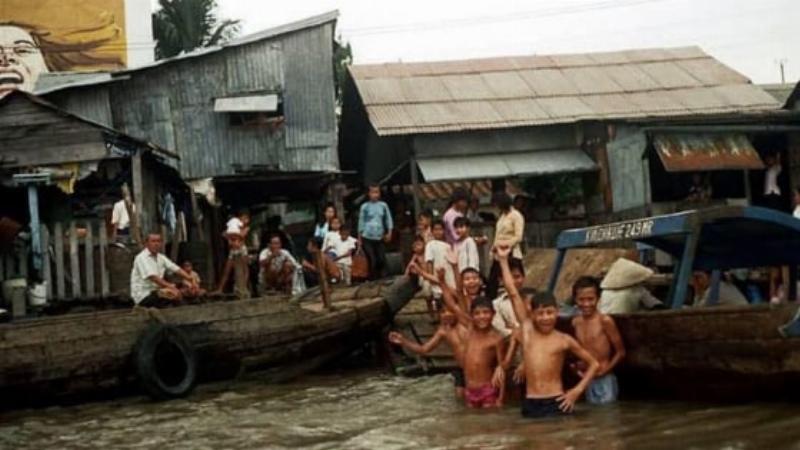 Một người đang chậm rãi đi bộ và quan sát các cửa hàng dọc hành lang Chung cư Tôn Thất Đạm, thể hiện tinh thần khám phá